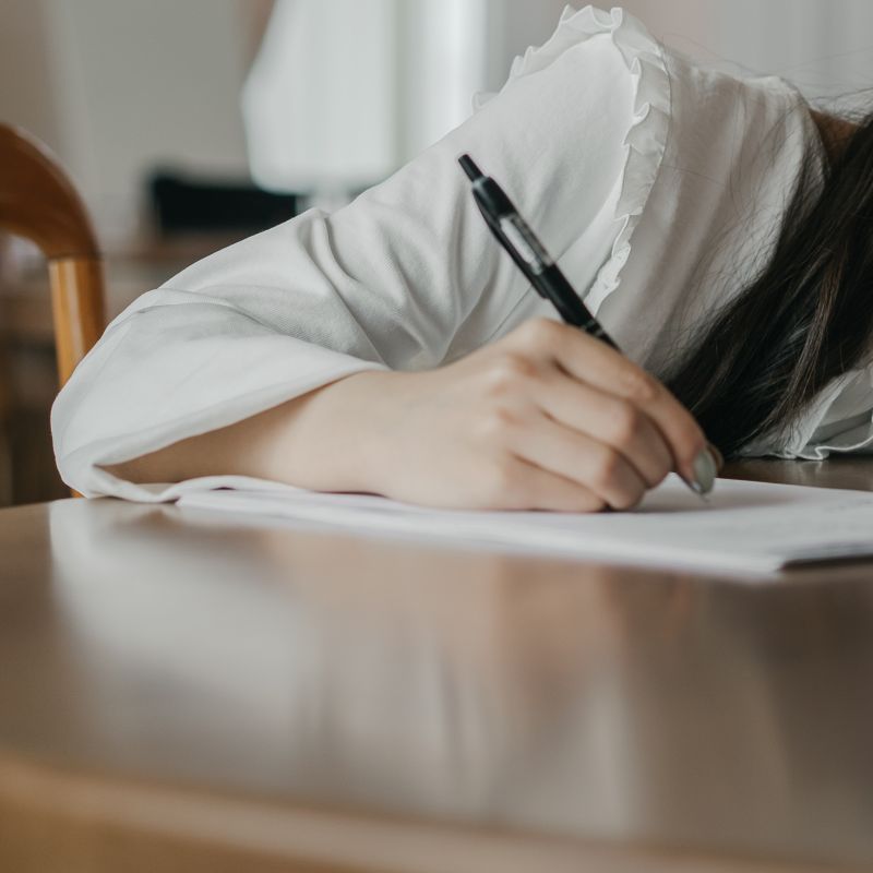 photo of woman writing on paper by Mikhail Nilov via pexels.com